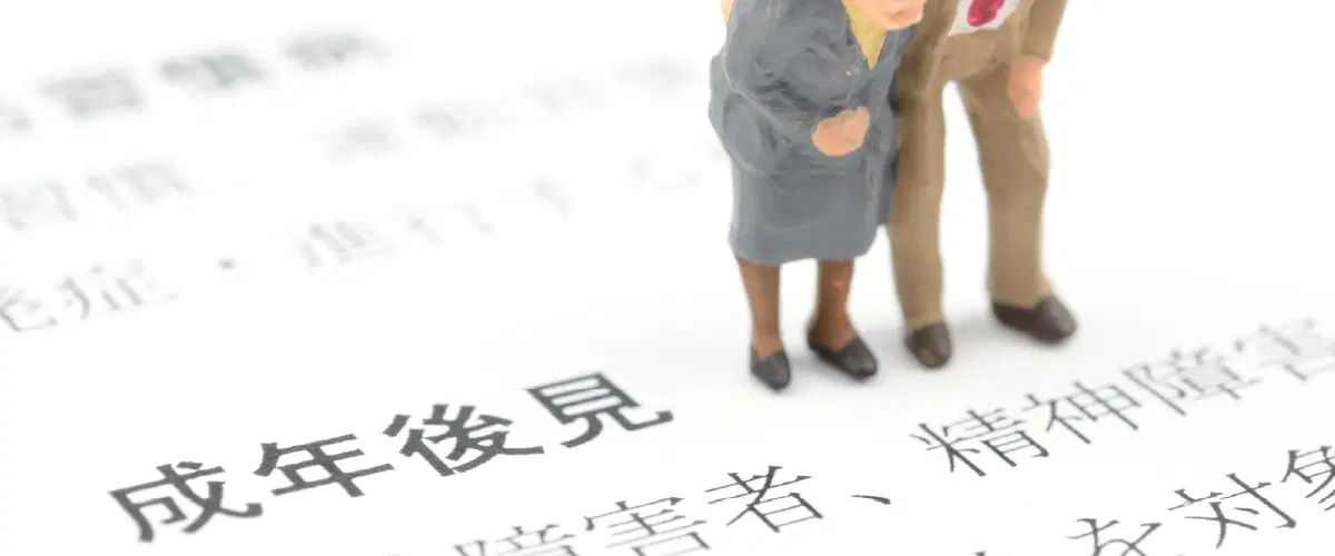 成年後見と書かれた書類と人形