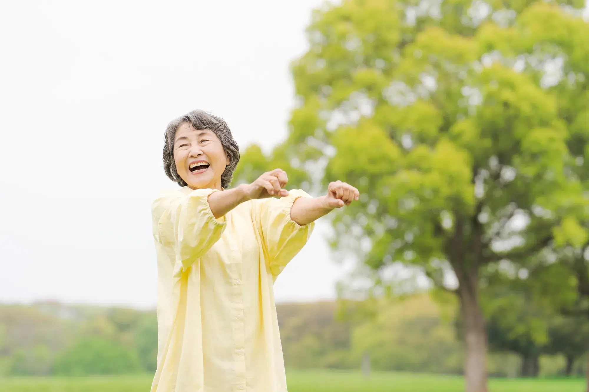黄色の服を着た女性が両腕を前に伸ばしている。
