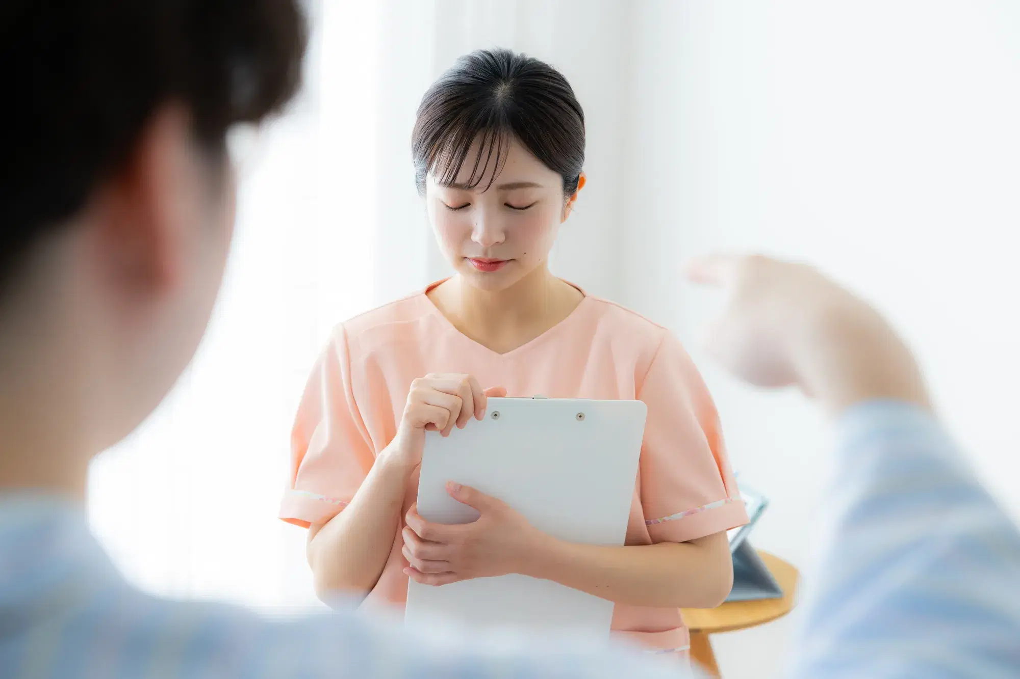 手前の水色の服を着た人間がピンク色の服を着た女性に指を指す
