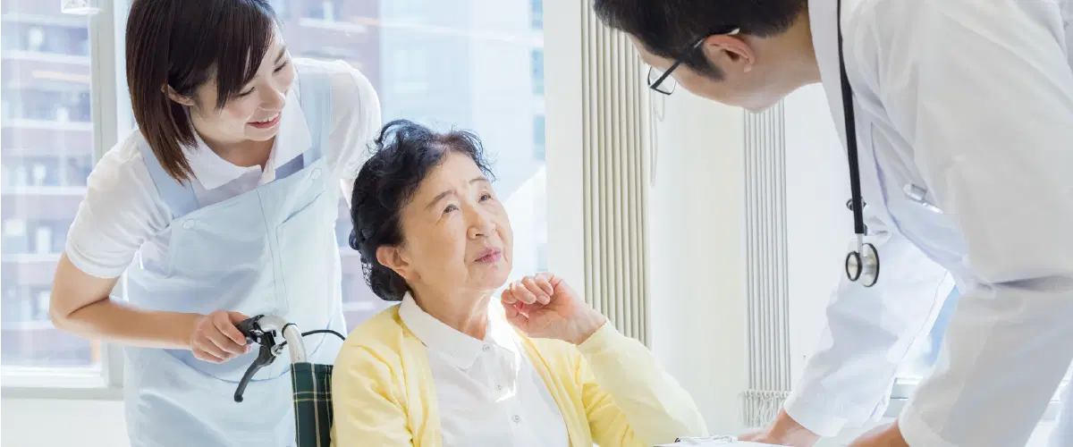車椅子の高齢女性が先生と話をしている様子