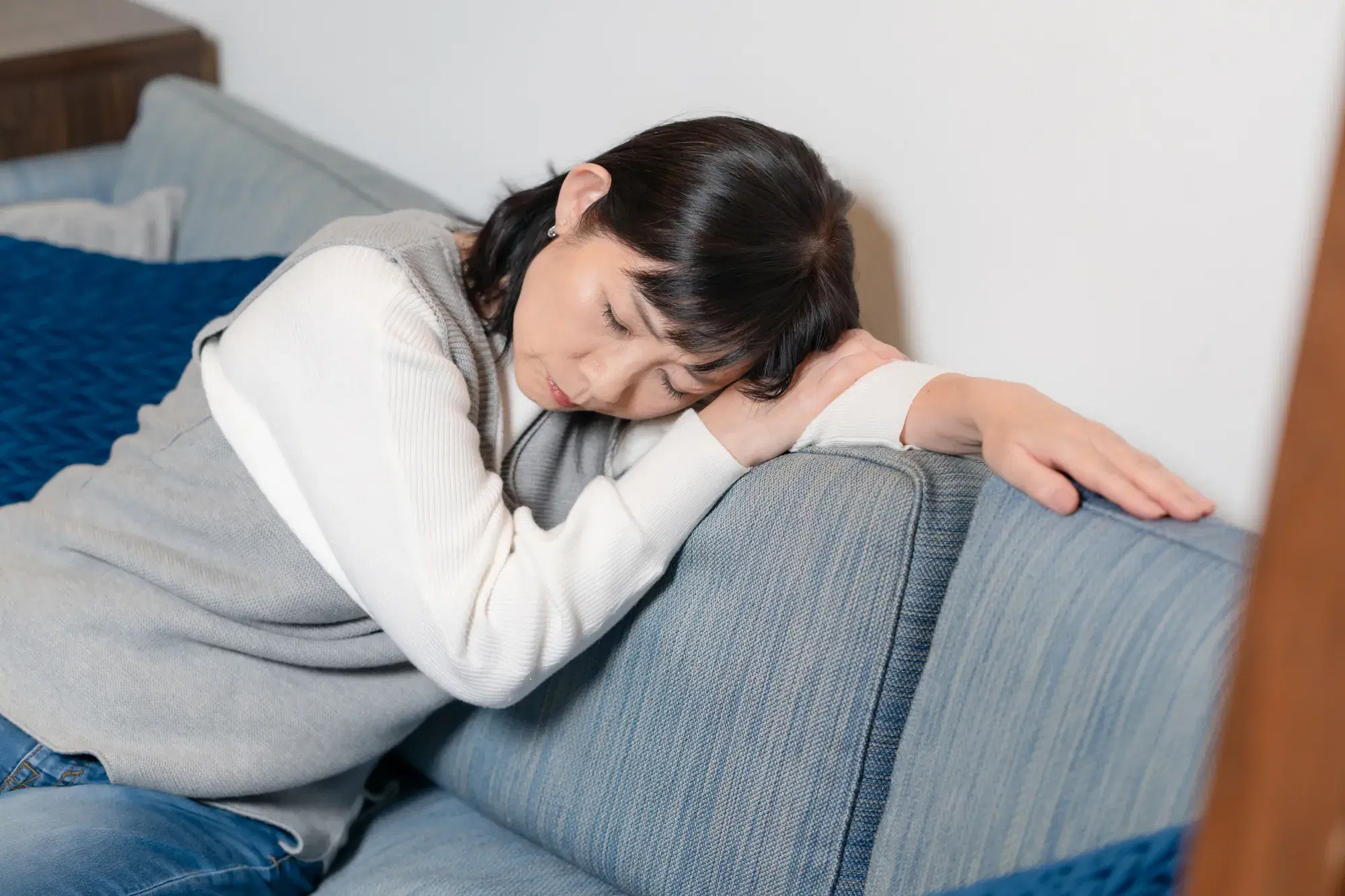 ソファで項垂れる疲れた様子の女性