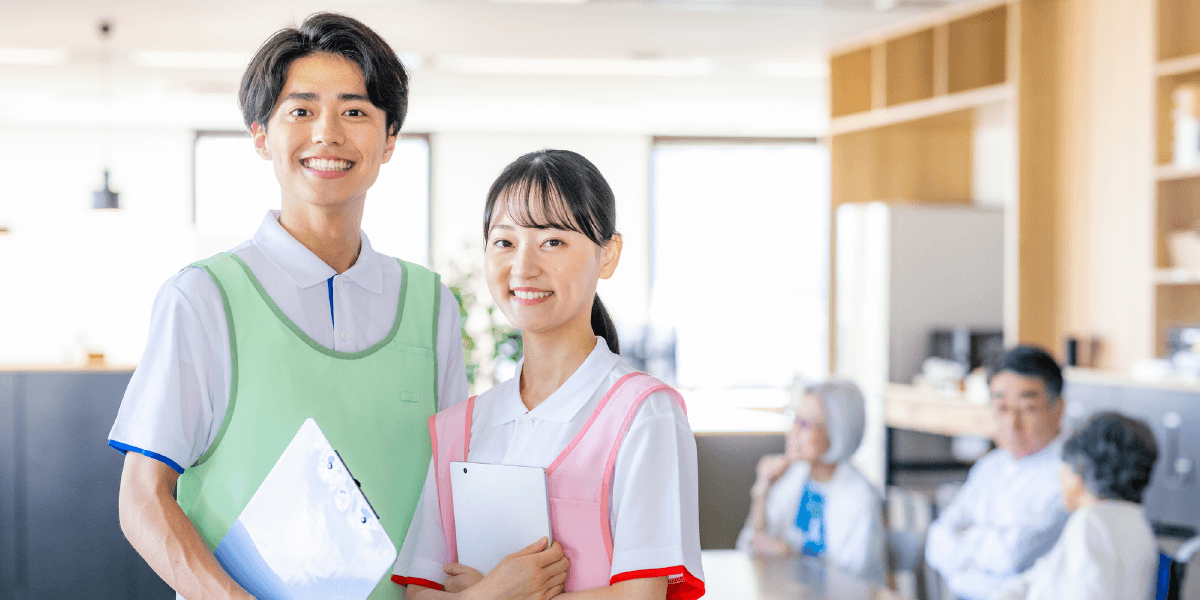 緑の服を着た男性とピンクの服を着た女性が笑っている