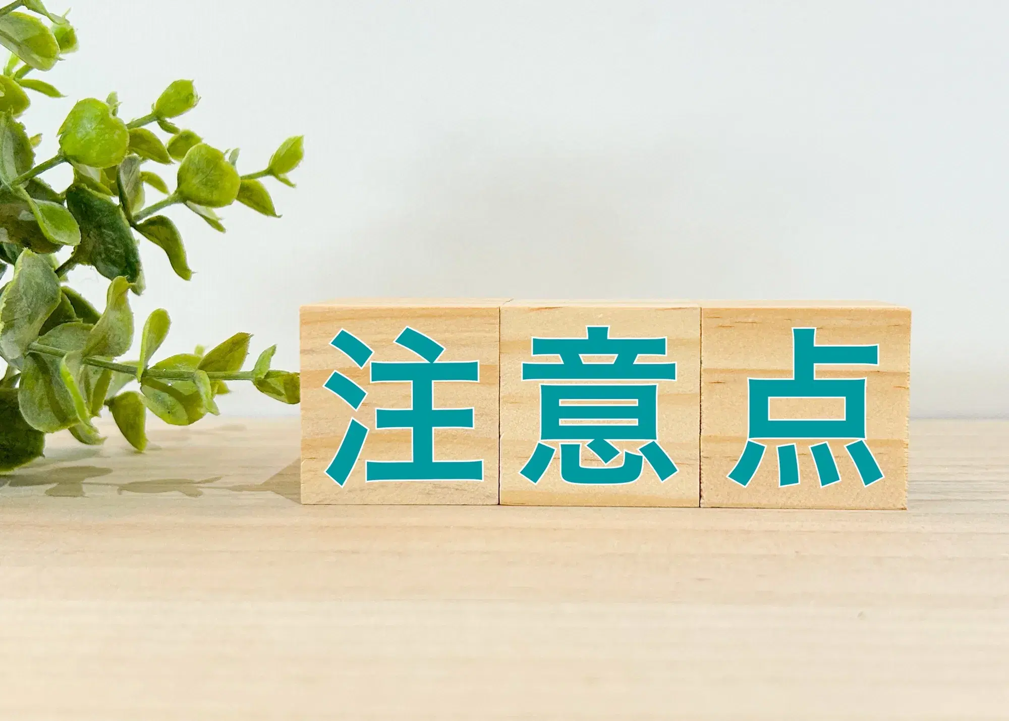 机の上に注意点と抱えた積み木が置いてある