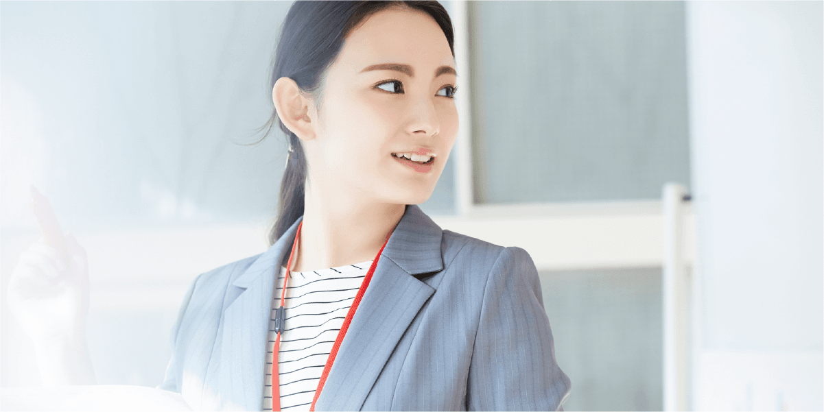 書類を持ち何かを説明する様子のスーツを着た女性