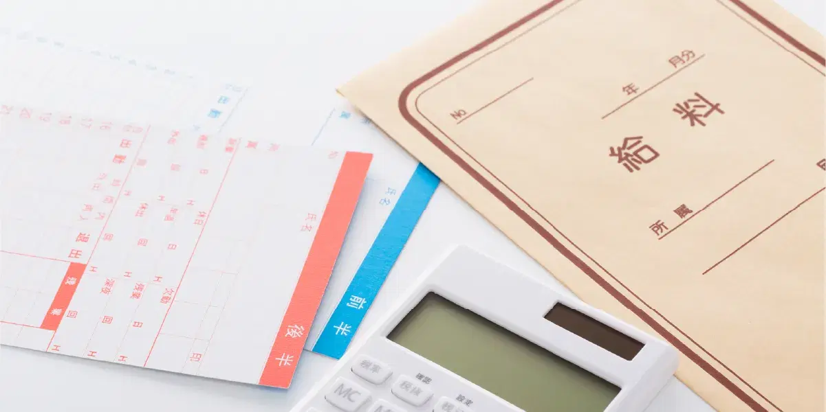 給料と書かれた封筒と計算機とタイムカード