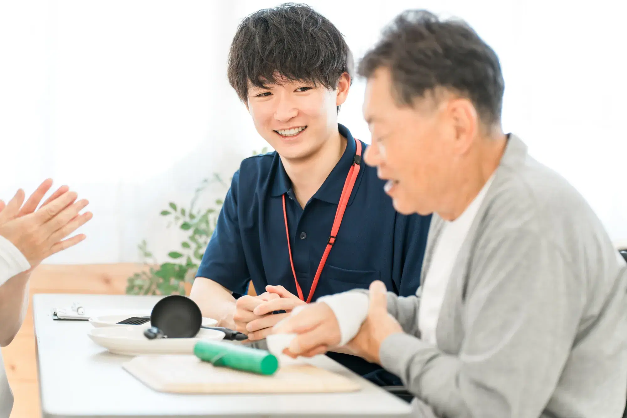 紺色の服を着た男性が年配の男性の介護
