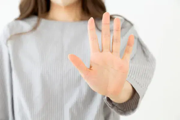 手のひらをこちらに向ける女性