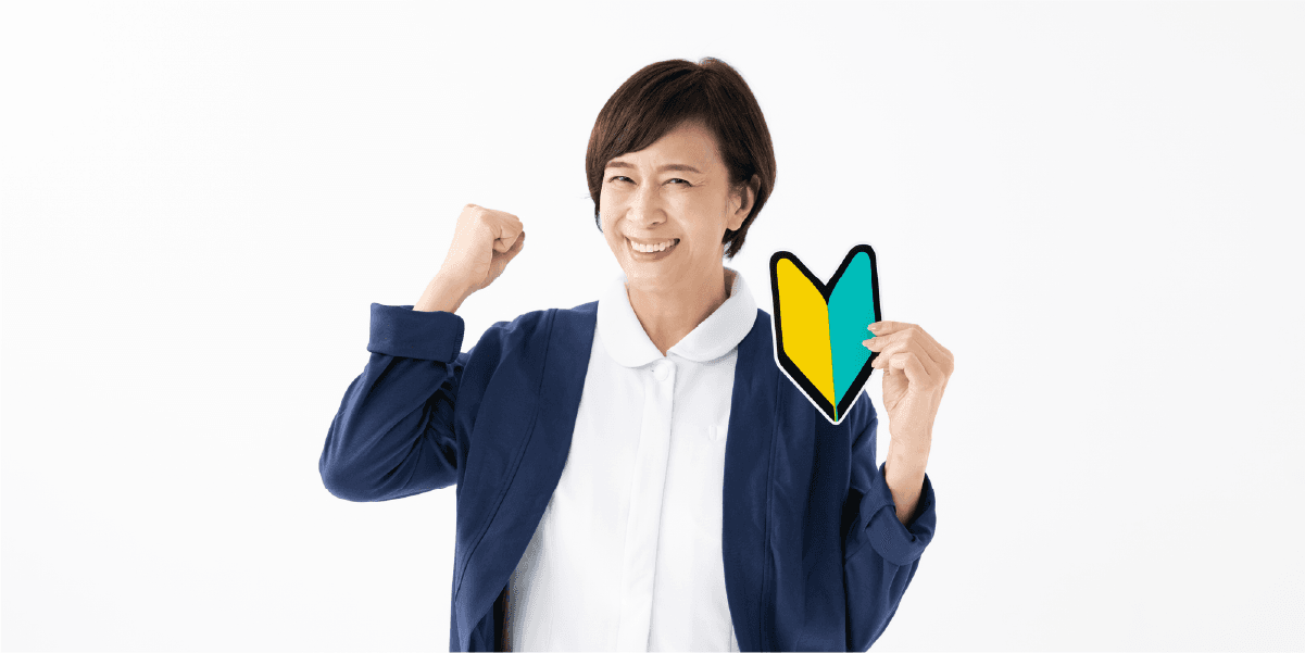初心者マークを持ってガッツポーズする女性