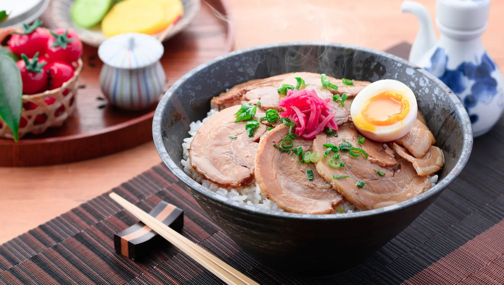 テーブルの上に肉の乗った黒い丼