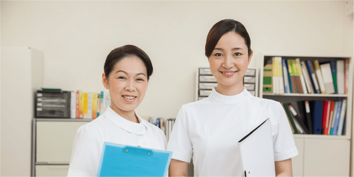 青と白のバインダーを持って、笑っている女性二人組