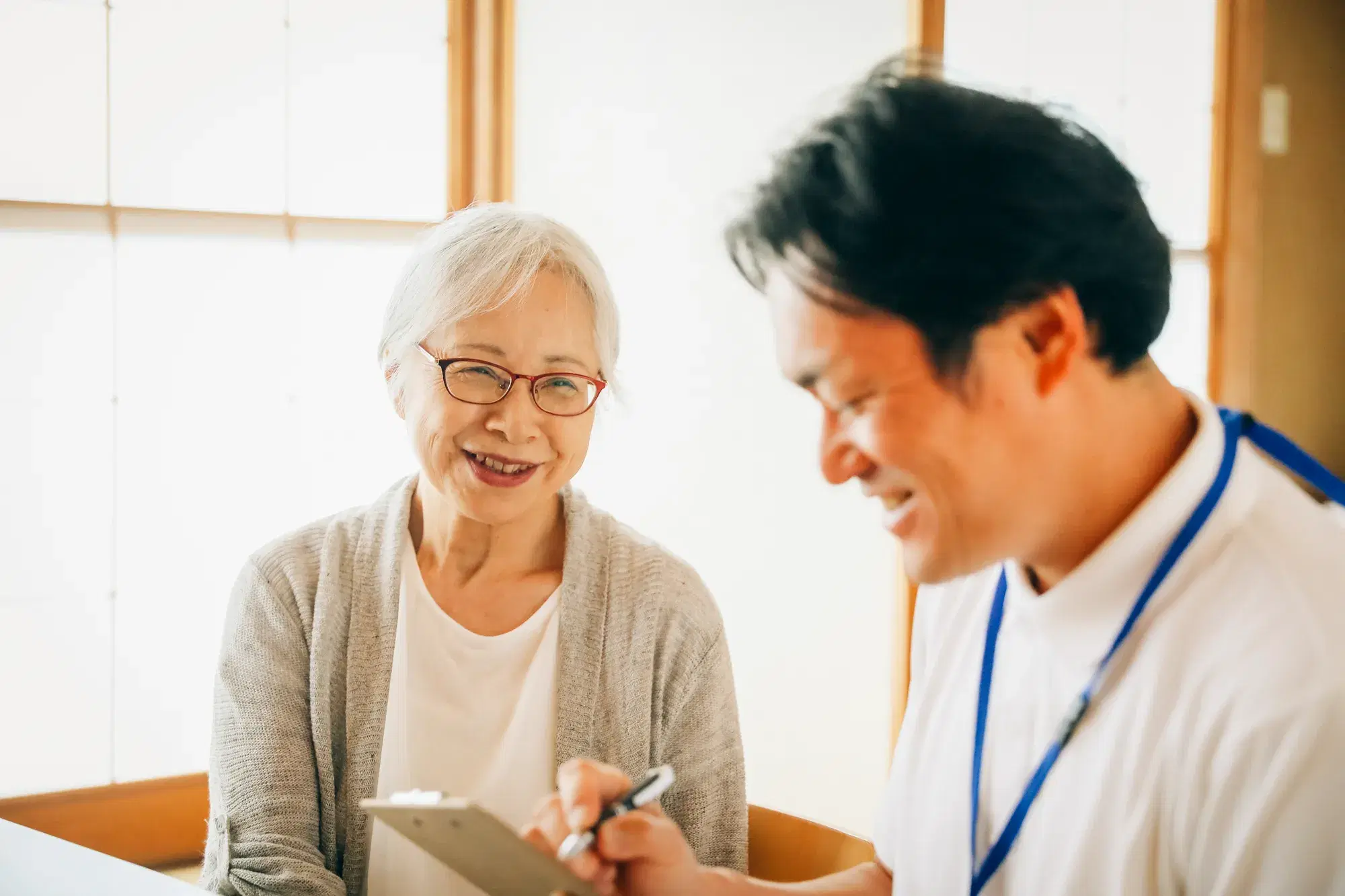 年配の女性を白い服を着た男性が介護