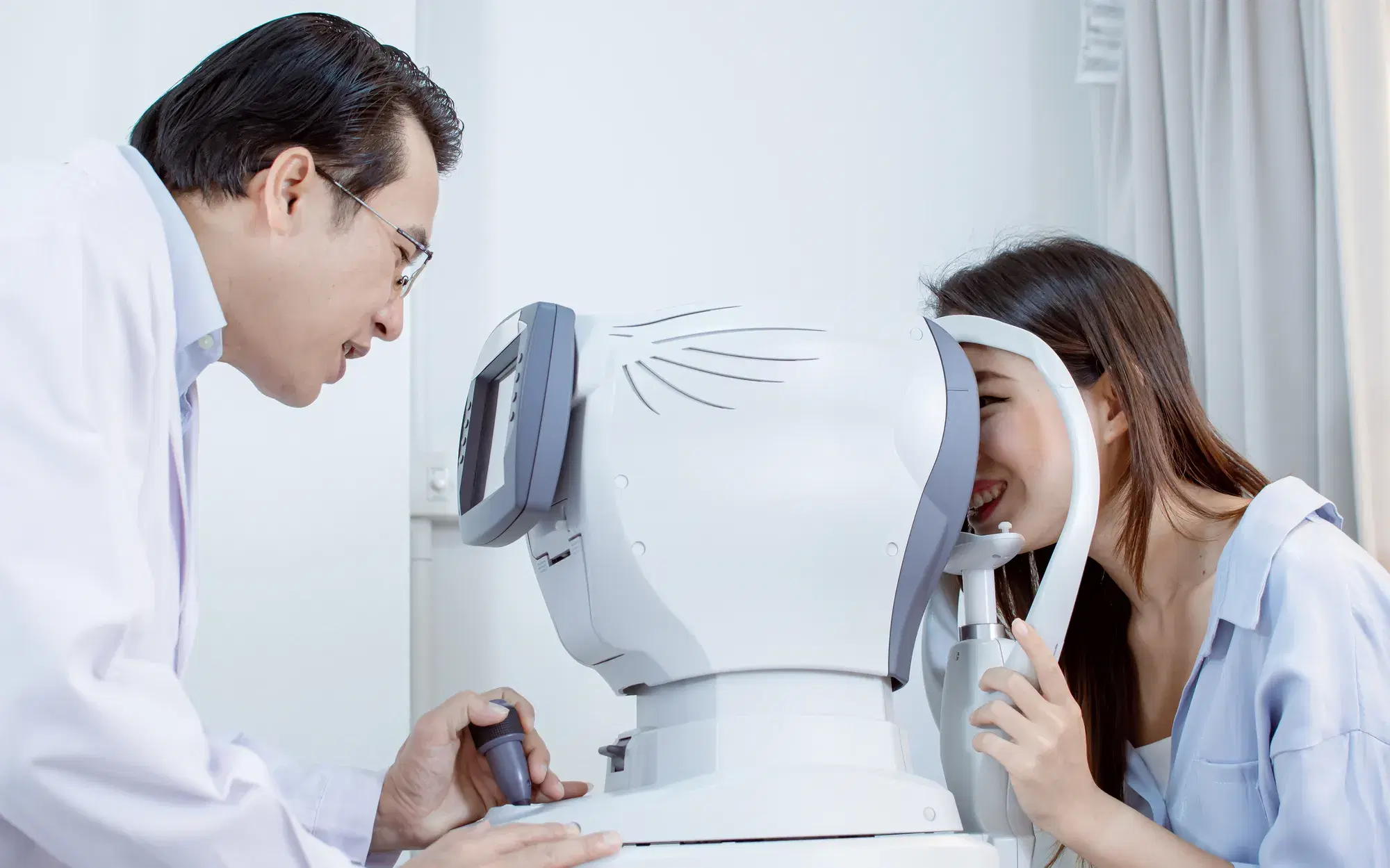 女性が眼科検診している様子を男性医師が見ている様子