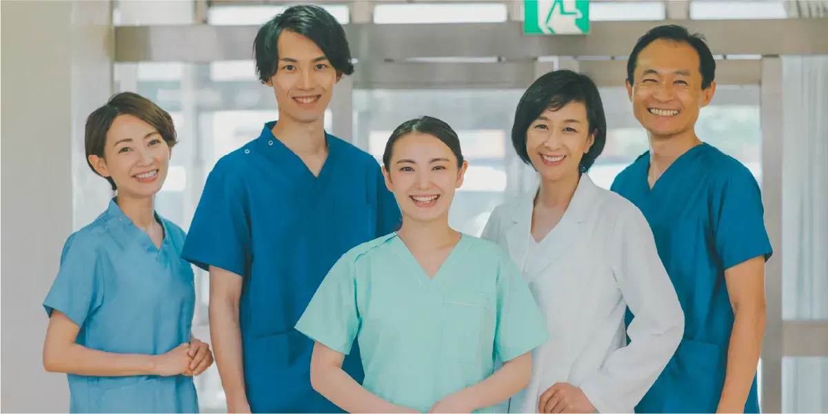 笑顔を向ける医療職員の男女たち