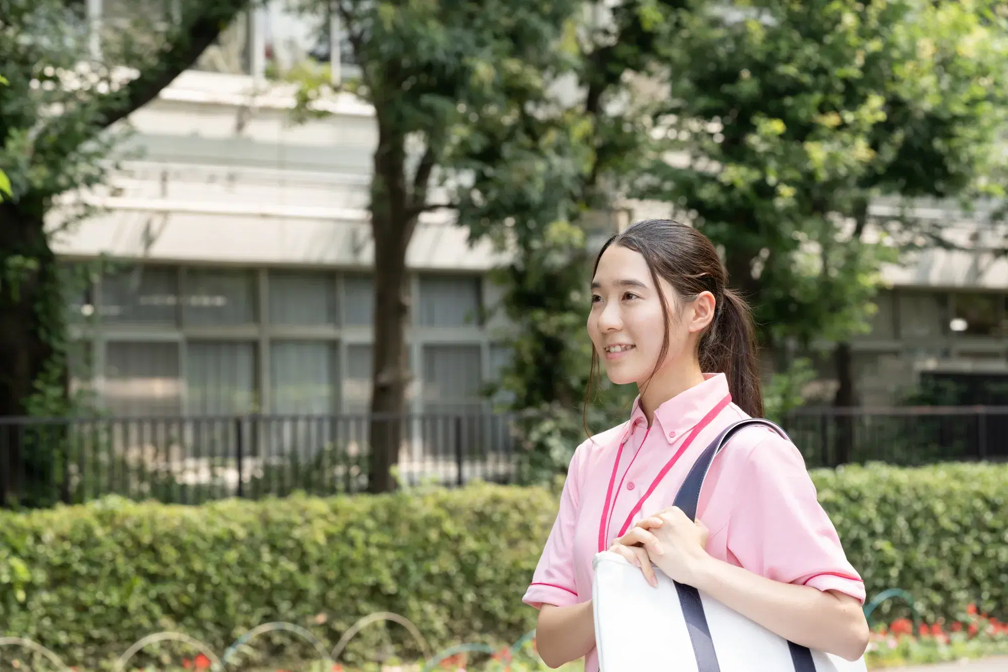 ピンクの服を着た医療従事者が外を歩いている