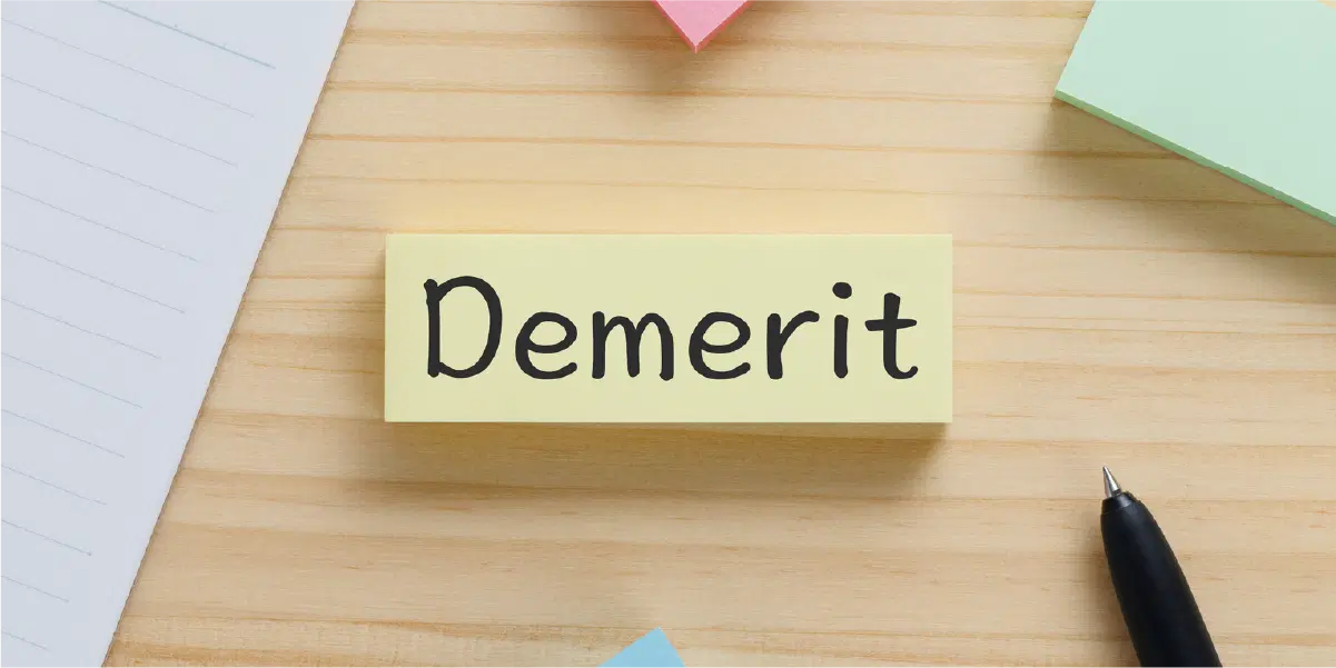 木の机の上にデメリット(Demerit)と書かれた付箋紙