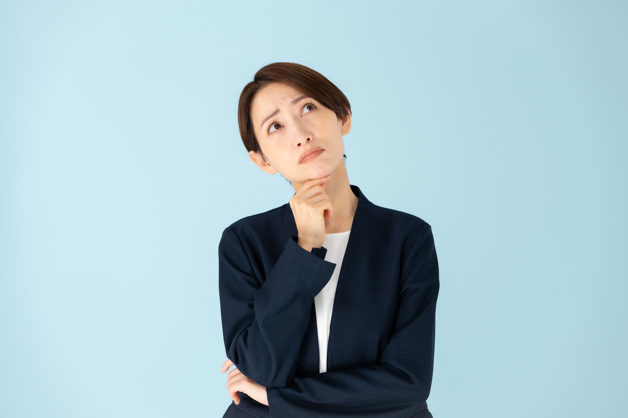 頸を傾げて悩む様子の女性
