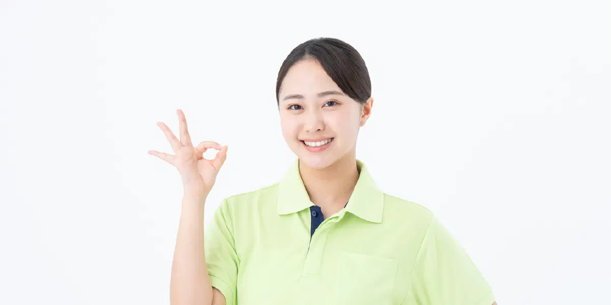 黄色い服を着て手で丸を作っている笑顔の女性