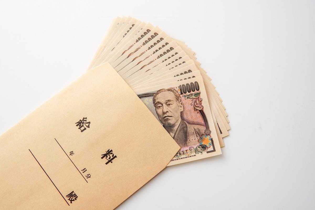 「給料」と書かれた茶封筒から溢れ出る一万円札の束