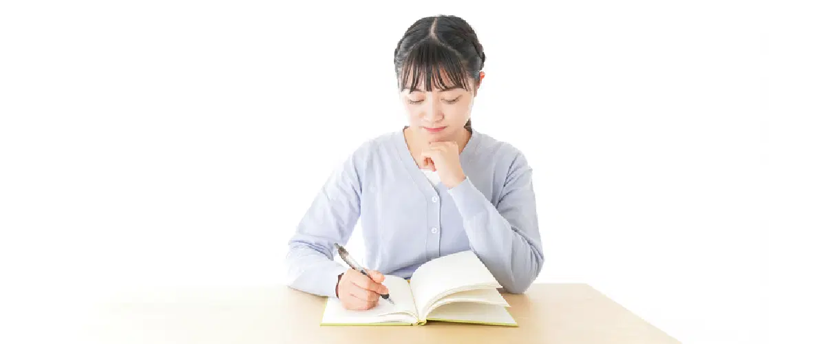 ノートを見ながら考え込んでいる女性