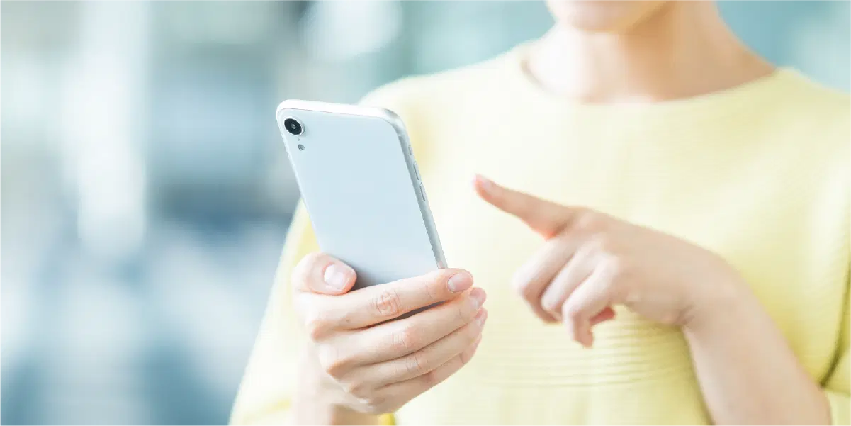 スマホを操作する黄色の服を着た女性