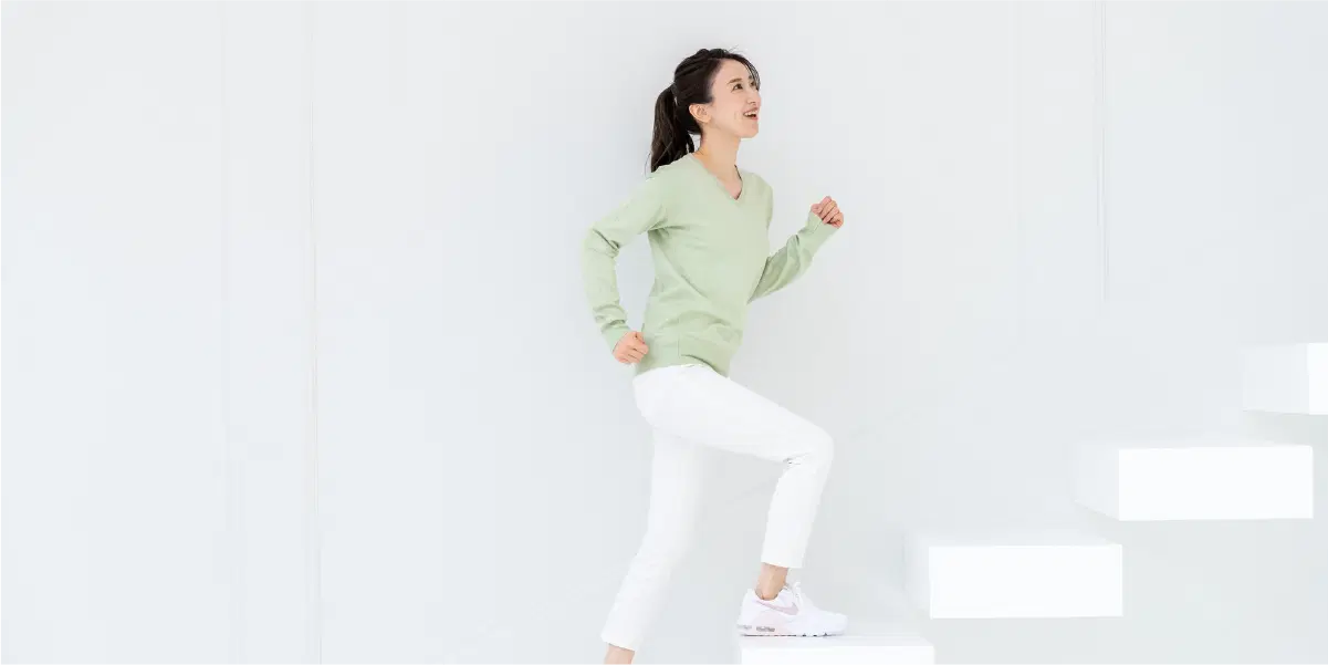 女性が階段を上りステップアップする様子