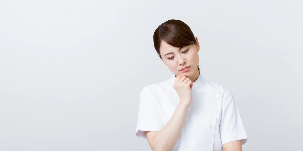 白い服を着た首を傾げる女性
