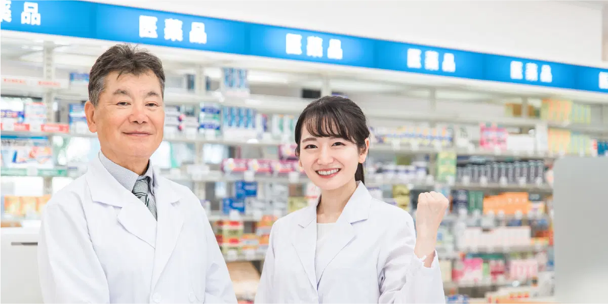 初老の男性と若い女性が白衣を着て笑っている