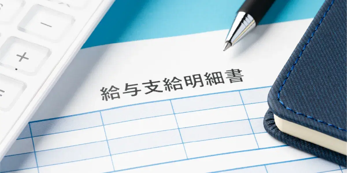 給与支給明細書と給料袋とペン