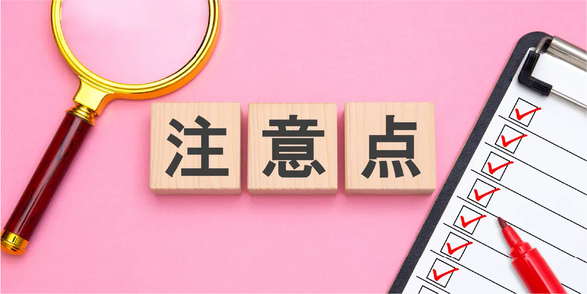 ピンクの背景に注意点と書かれた木の立方体が三つ並び、虫眼鏡と赤ペンでチェックされているチェックリスト。