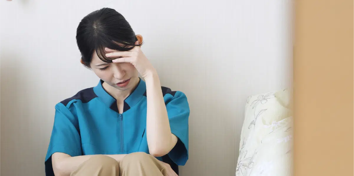 座り込み頭を抱える女性